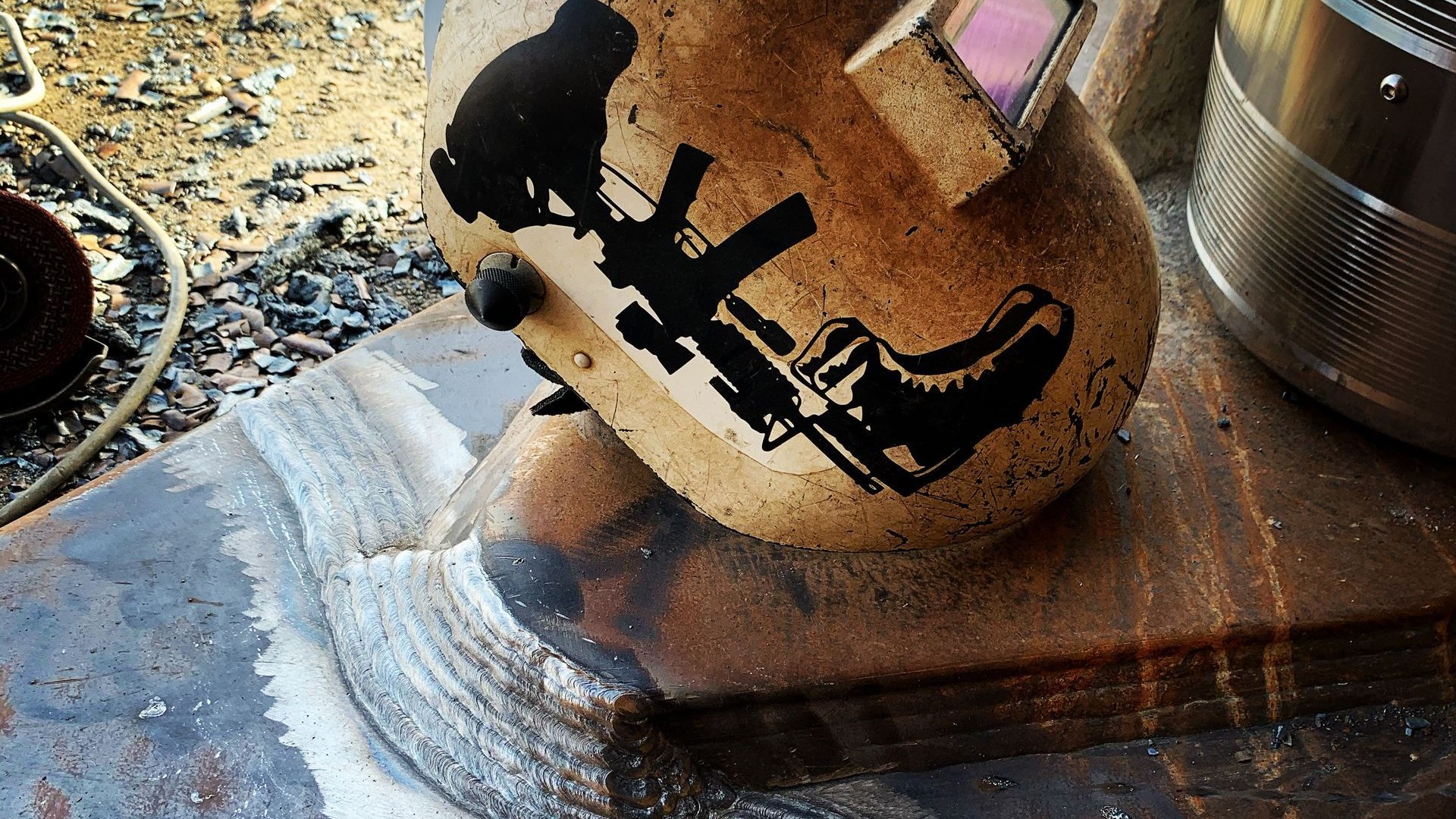 Welder with helmet and sparks welding pipe